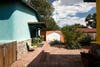 brick patio in front of turquoise adobe home