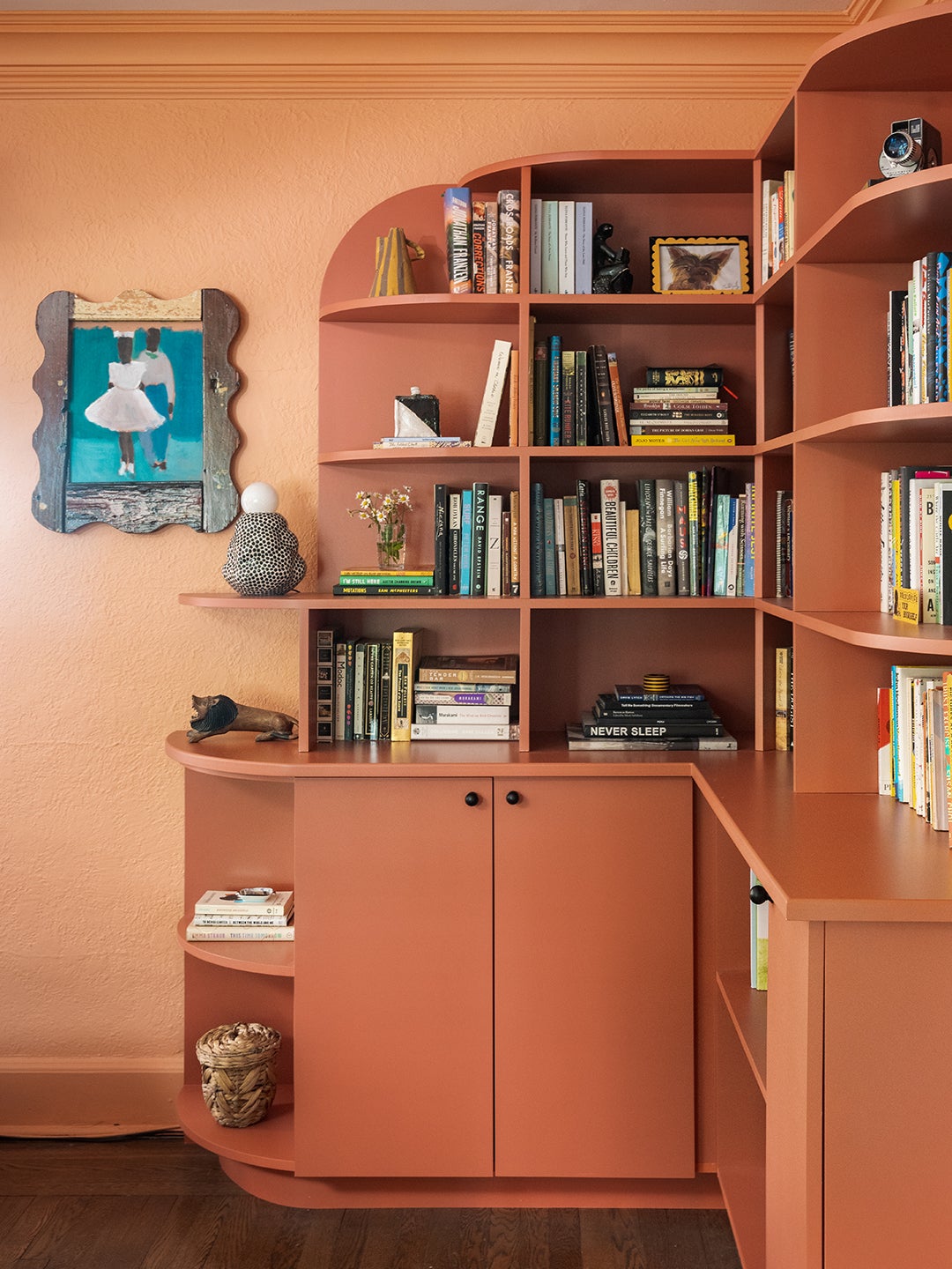 curved peach built-in bookcase against peach walls
