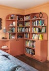 curved peach built-in bookcase against peach walls