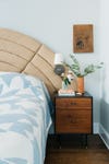 arched quilted headboard and wood nightstand