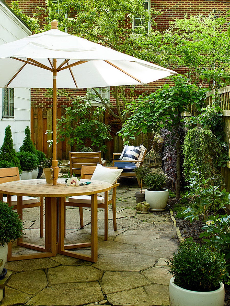 flagstone patio with garden white umbrella and wooden dinette set