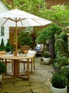 flagstone patio with garden white umbrella and wooden dinette set