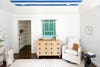 wood dresser with knobs that match blue-striped ceiling