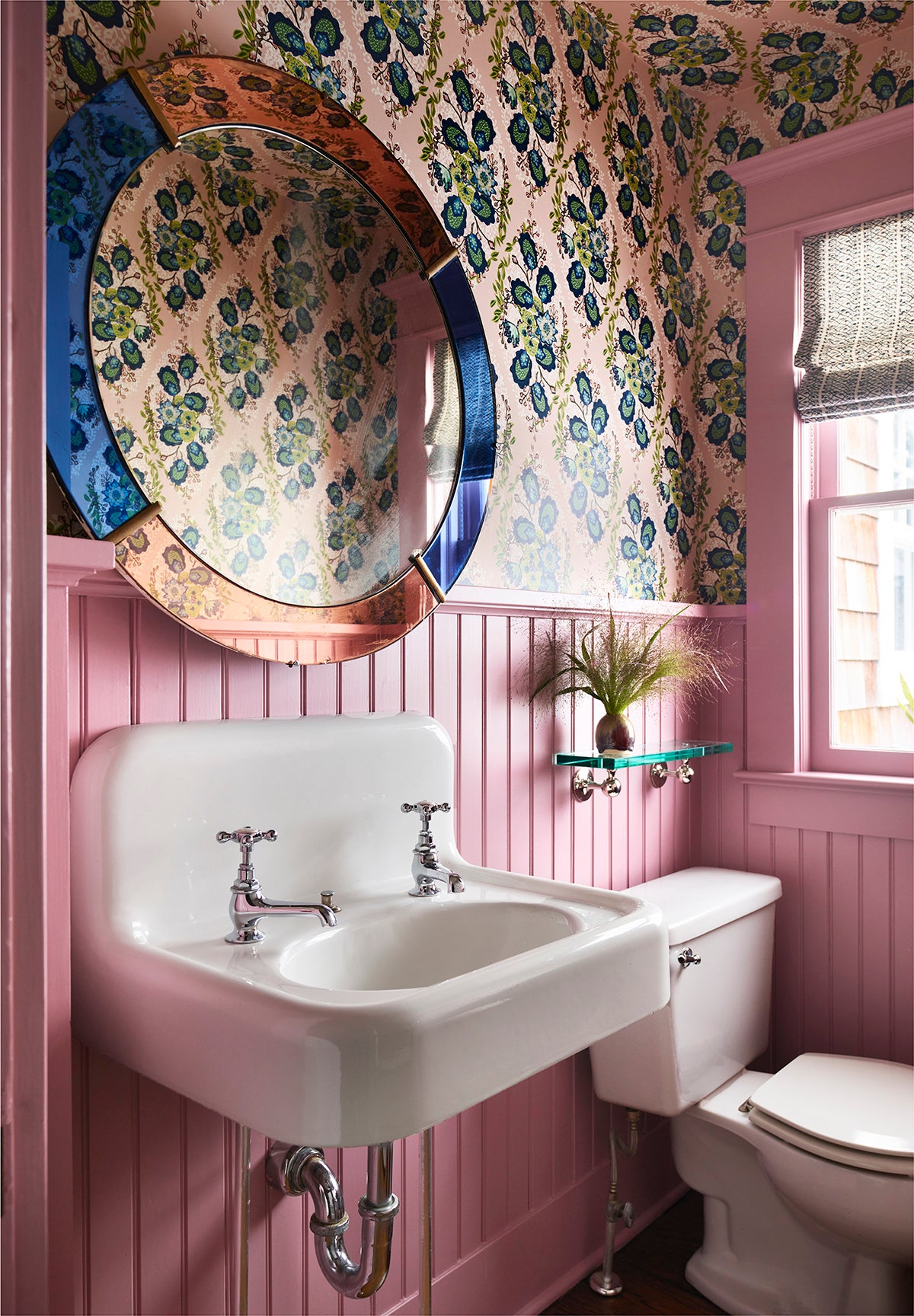 pink bathroom with floral wallpaper and vintage glass mirror
