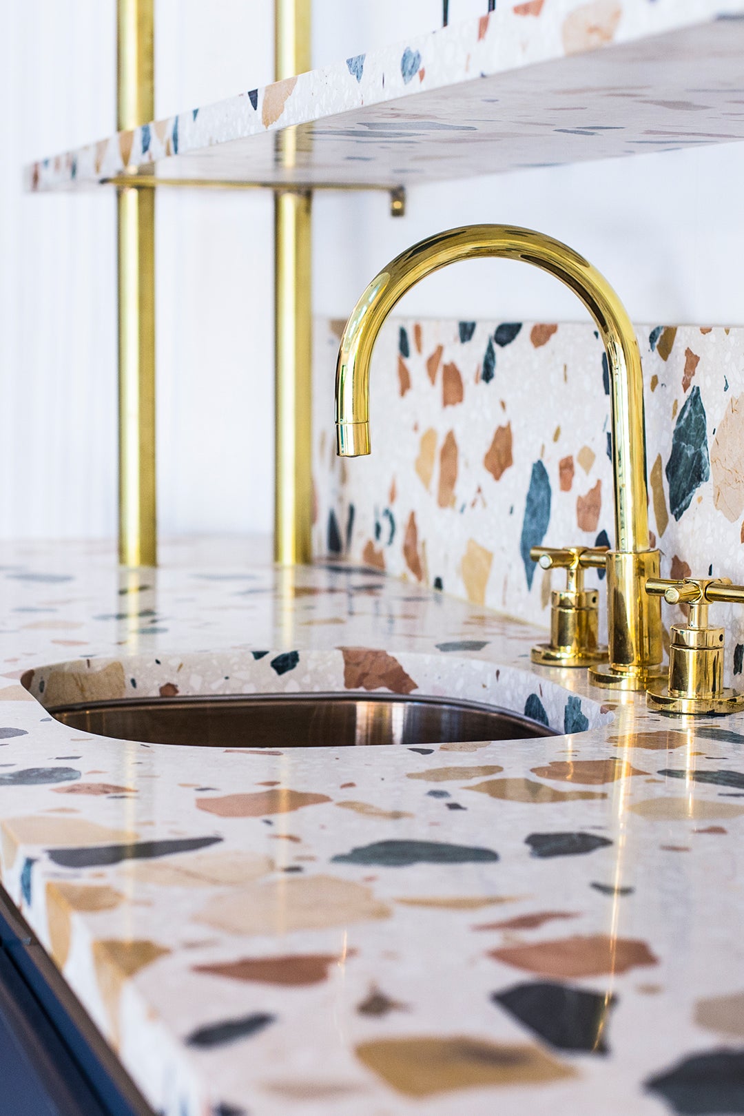 terrazzo counter tops with gold hardware.