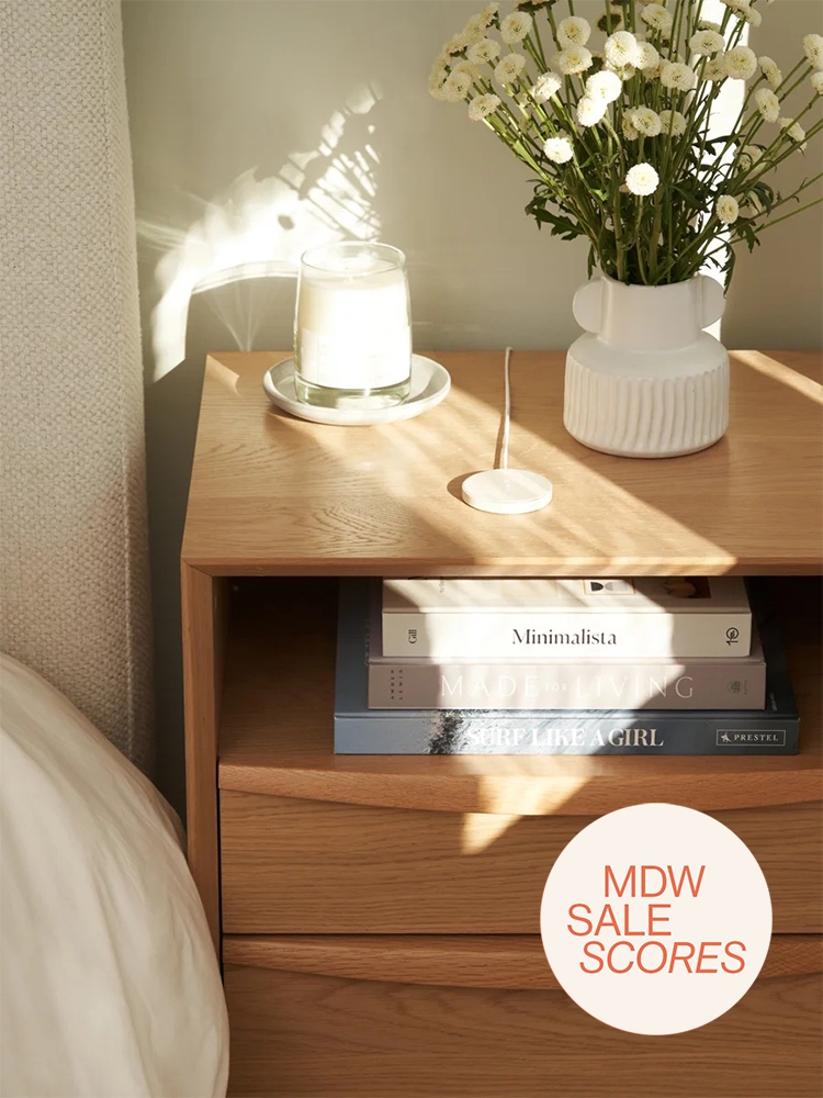 Bone white Classics wireless charger on nightstand with glasses and vase of flowers