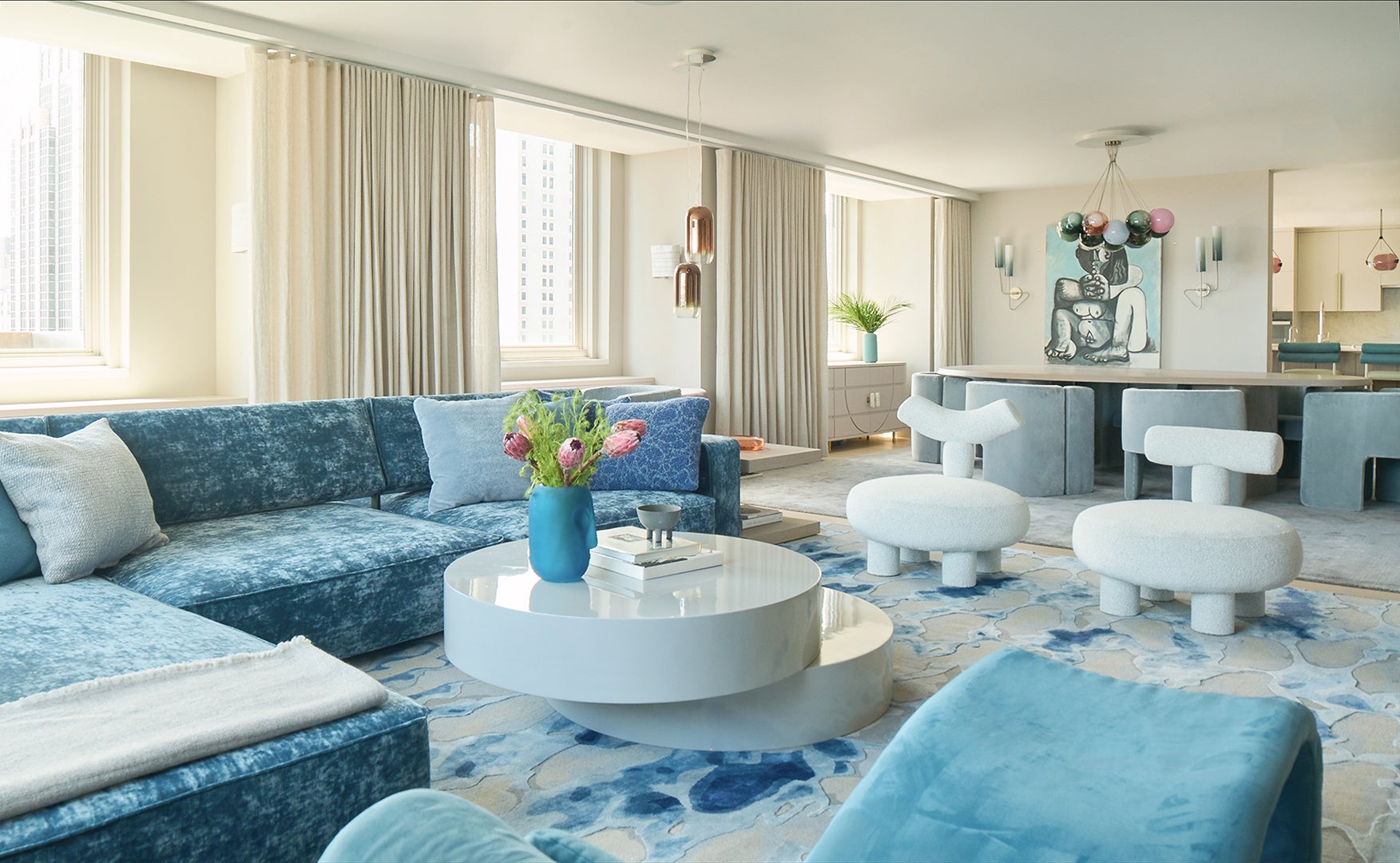 living room with blue velvet sectional and white armchairs