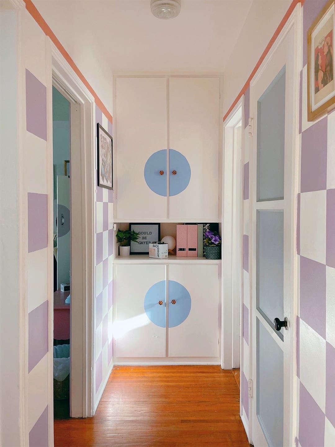Hallway with Checkered Walls and Blue circle cabinets