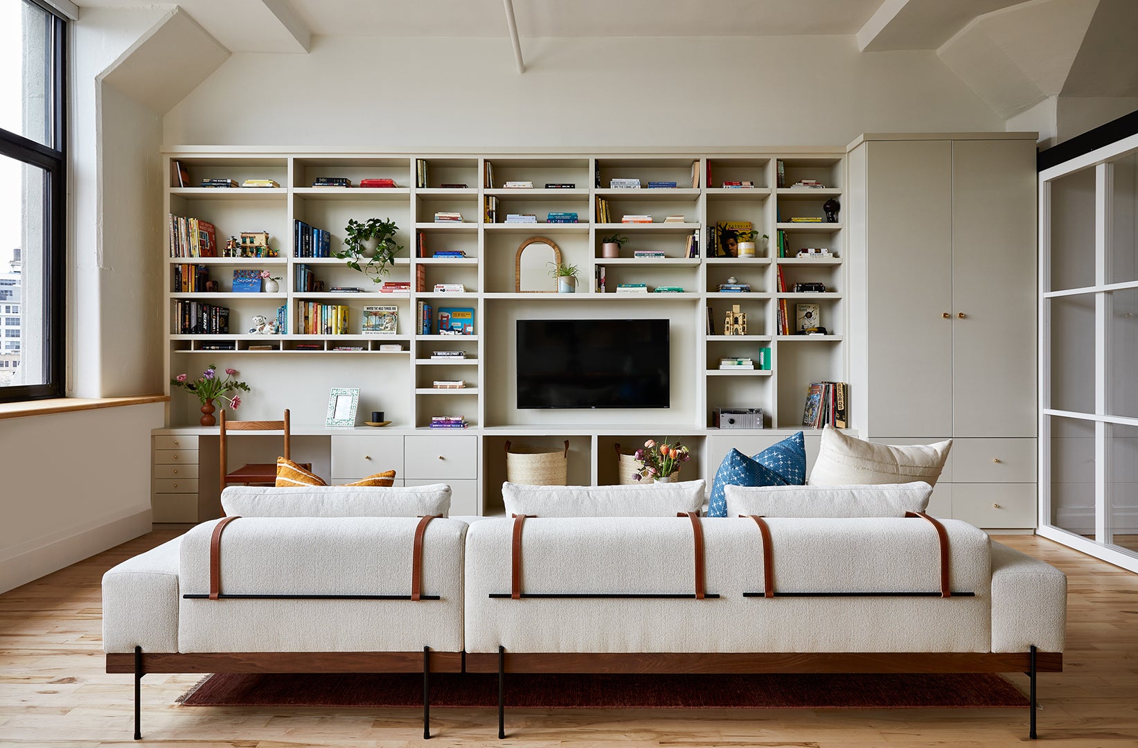 low-slung white sofa facing built-in bookshelves
