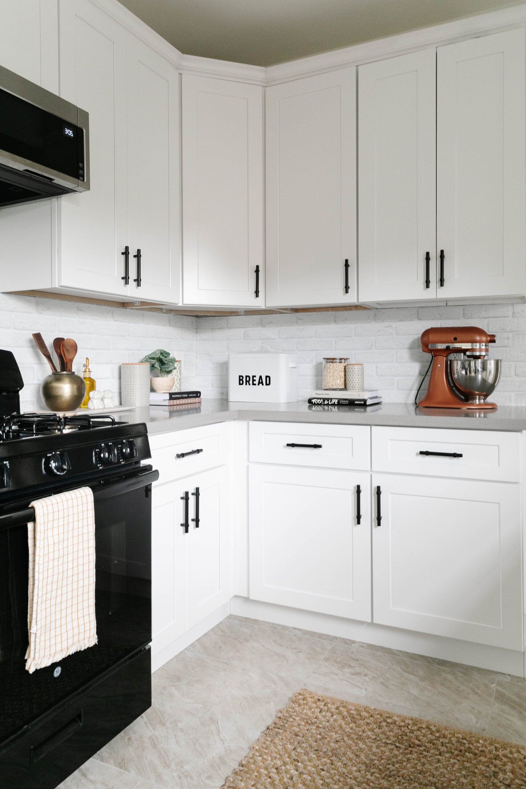 corner kitchen with white cabinets and black hardware