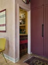 yellow walk-in pantry in oxblood red kitchen