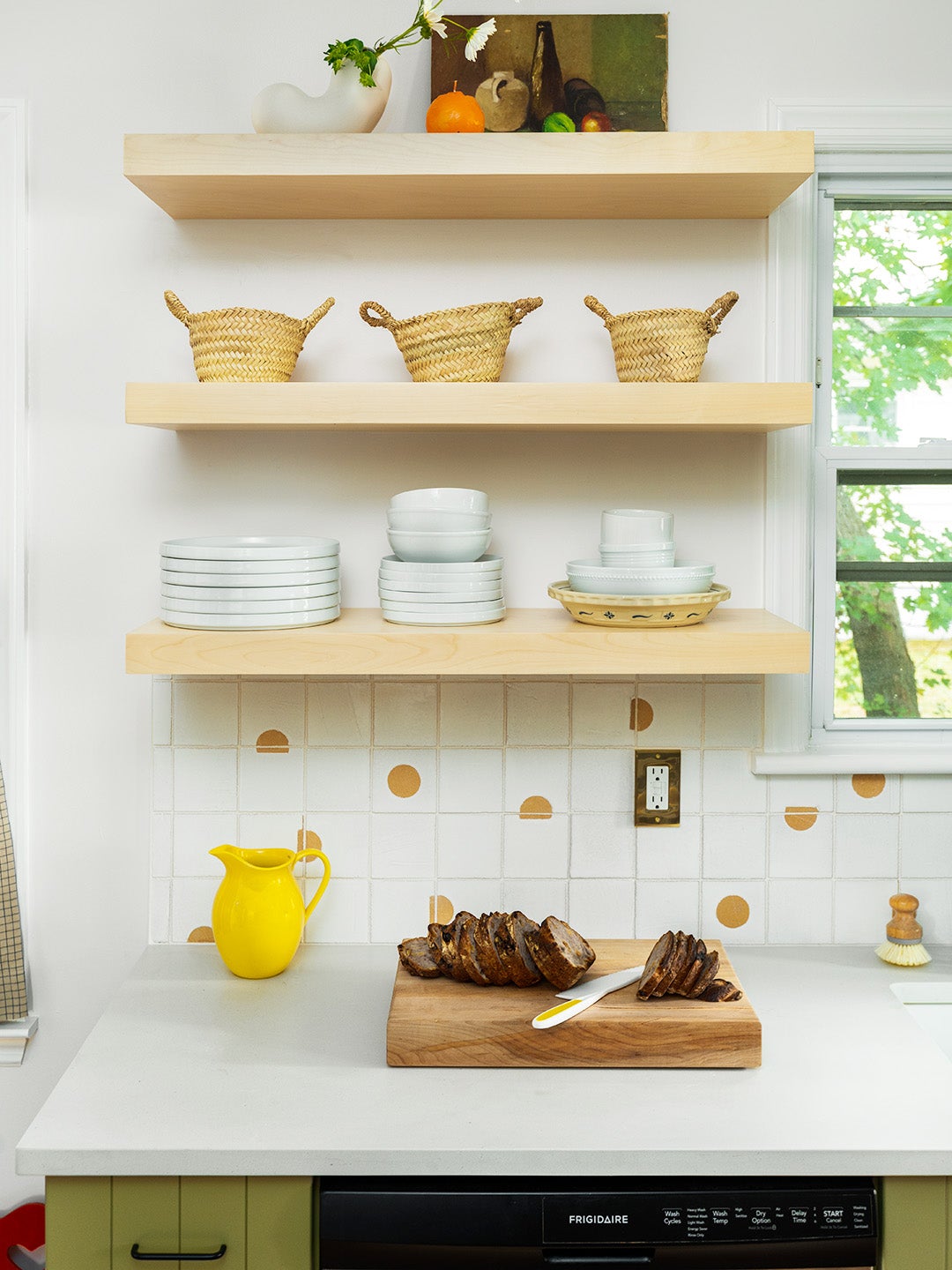floating wood shelves above white dotted tile