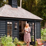 woman in dress standing outside black backyard studio