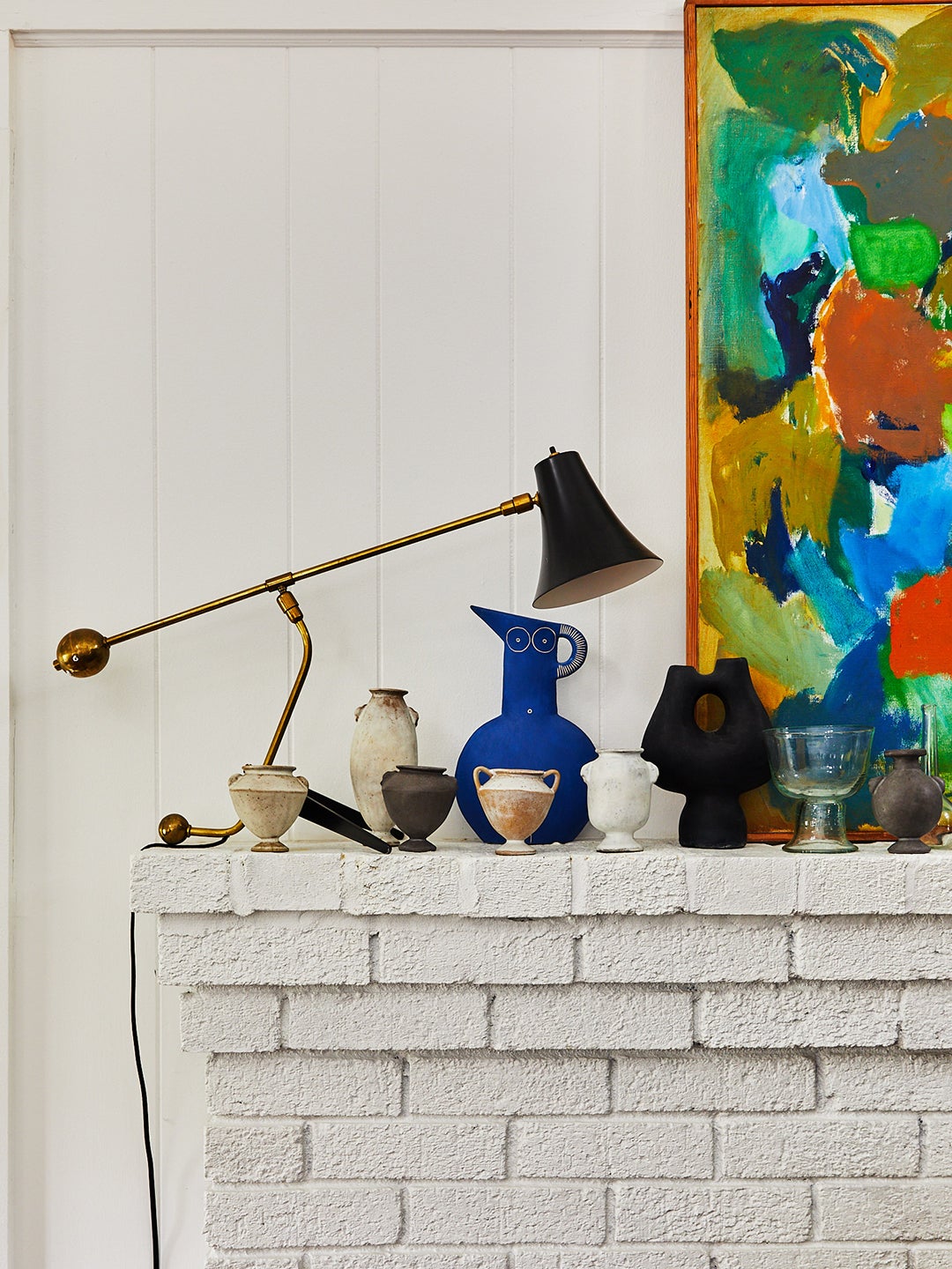 collection of vases on white brick fireplace