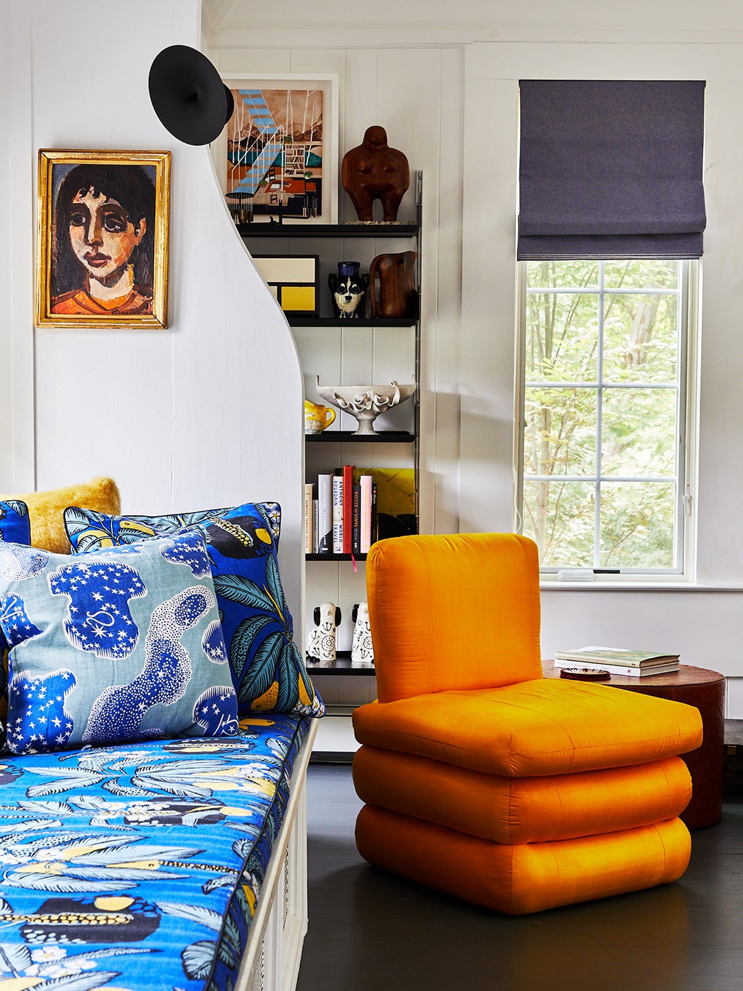 bright orange chair next to patterned blue window seat