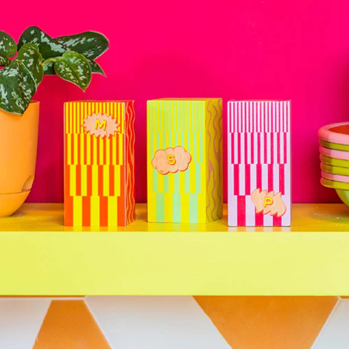 Set of MSG, salt, and paper shaker set colorful stripes on yellow shelf