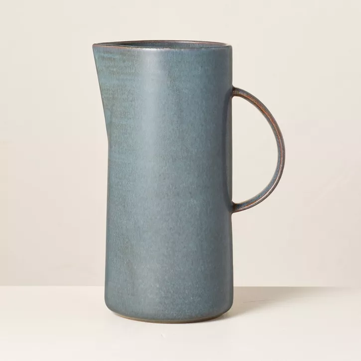 Sterling blue stoneware pitcher against a cream background.