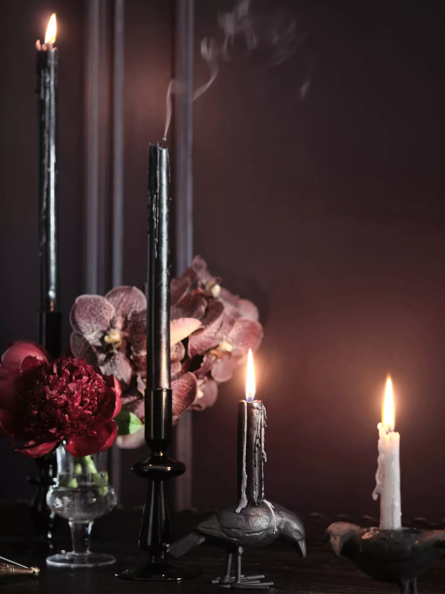 Black tapered candles on a dining room table.