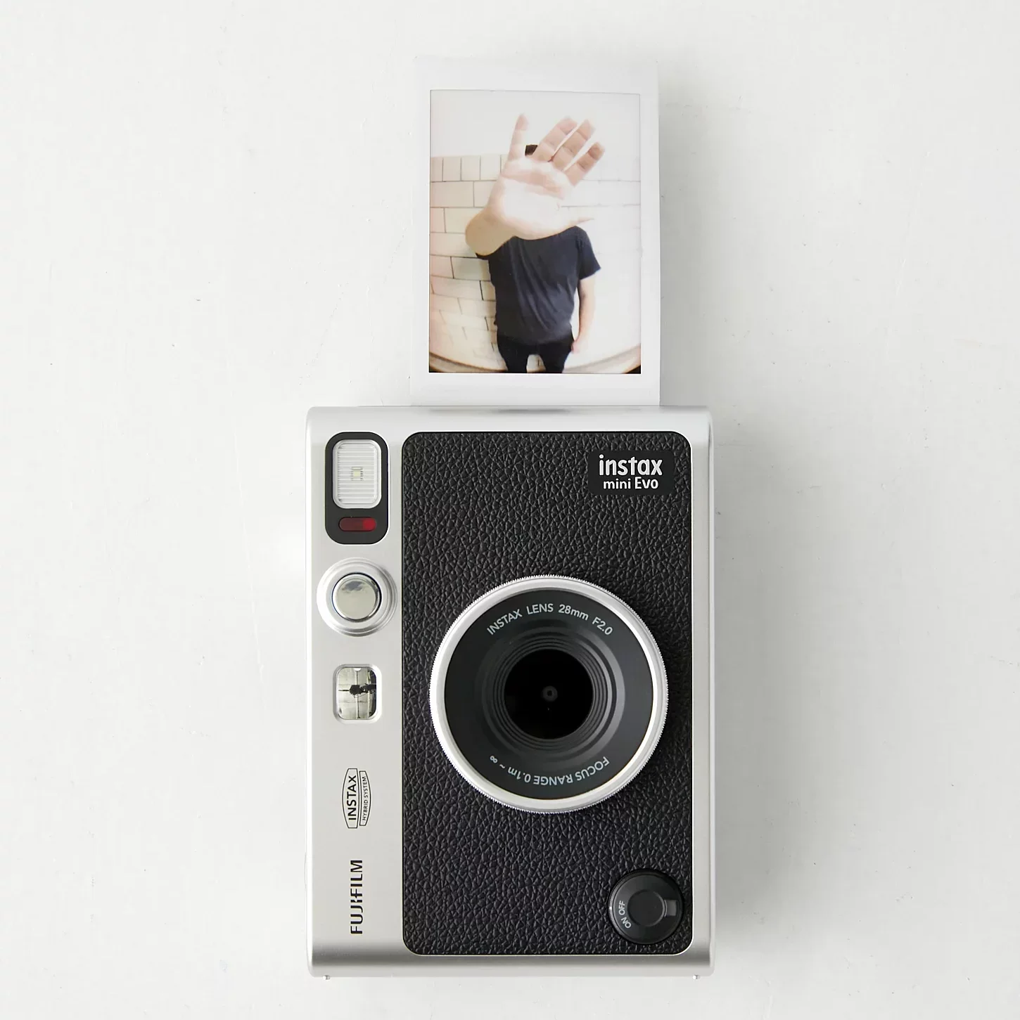 Instax Mini Evo Hybrid Instant Camera producing a poloroid against a white background.