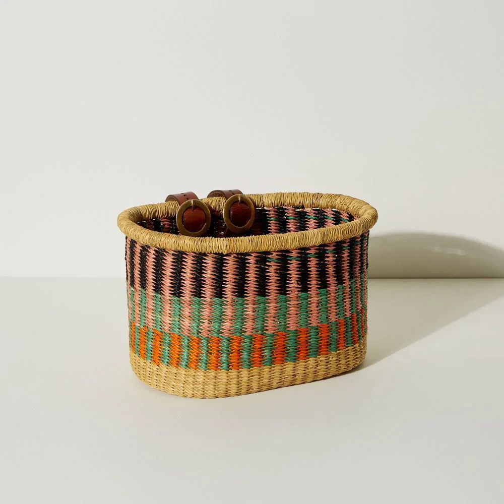 Multicolor woven basket with two adjustable leather straps against a white background.