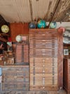Several tall and staggered wooden drawers with several globes sitting a