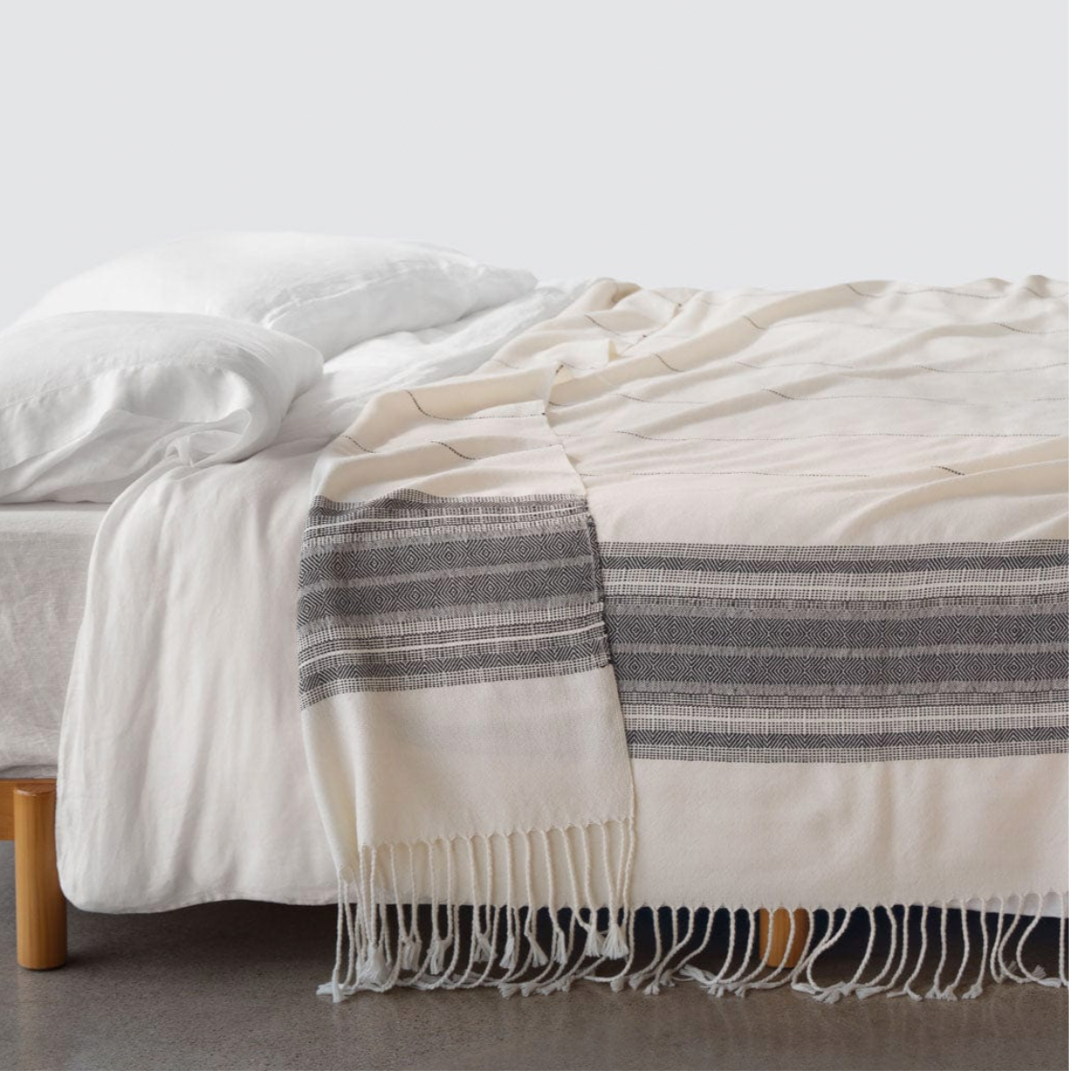 white blanket with gray stripes on side