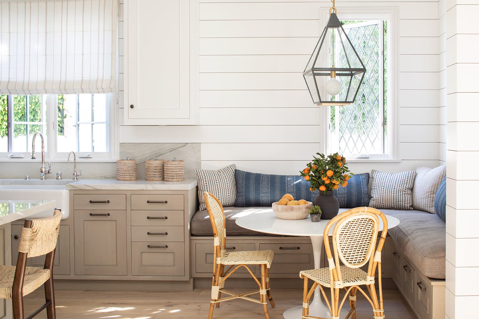 white shiplap kitchen with L-shaped breakfast nook