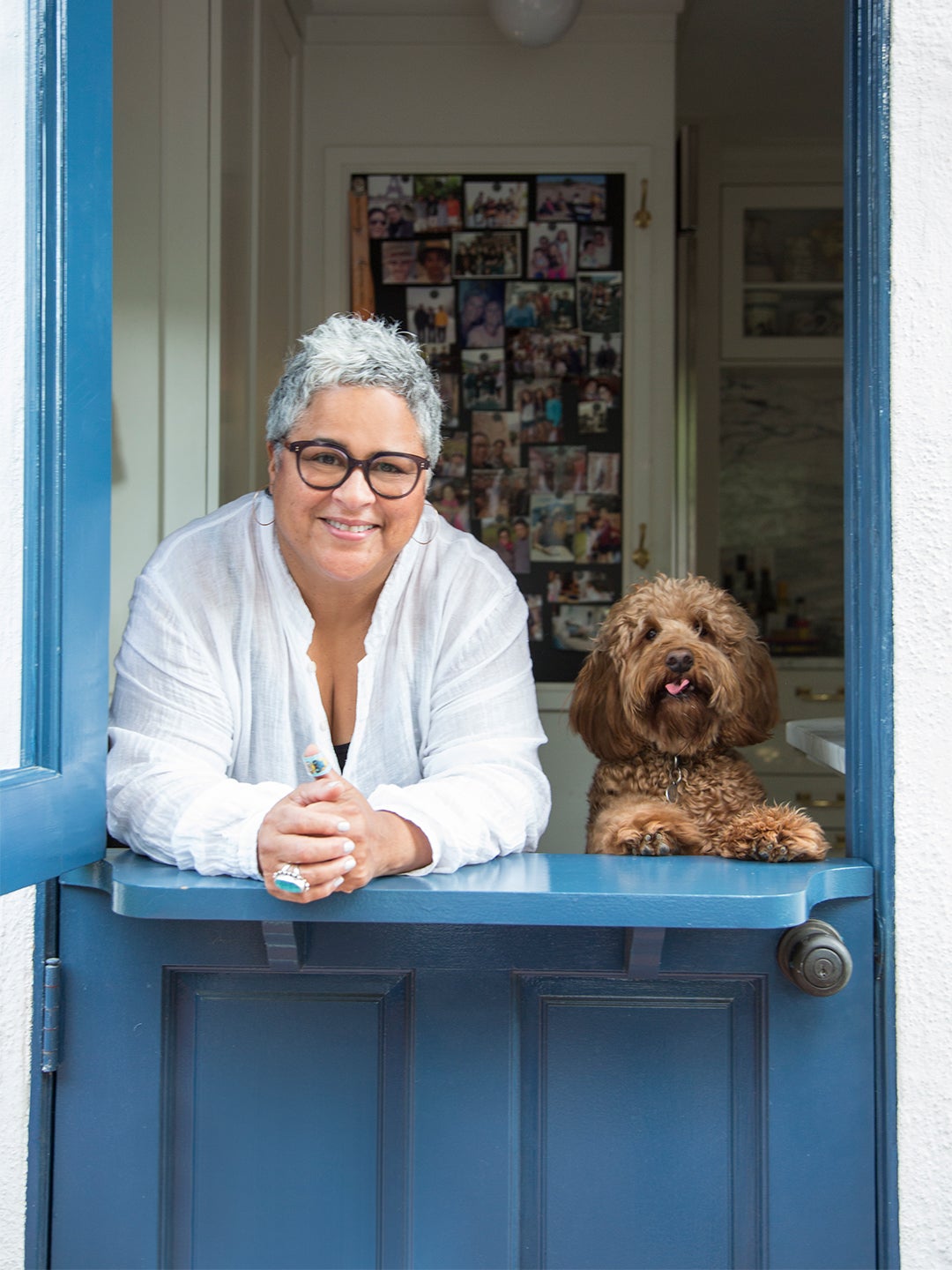 woman and dog leaning on blue dutch door