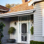Front door entrance of Edwardian home in Melbourne with potted trees outside