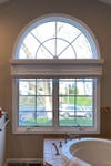 arched window in dated 1990s bathroom