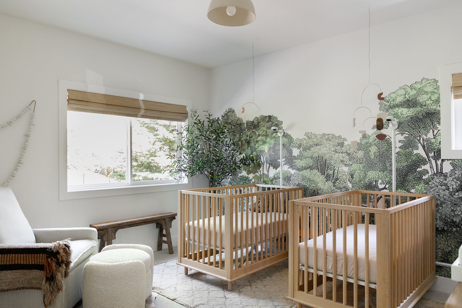 Twin nursery with woodsy wallpaper