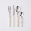 Four pieces of flatware with ivory acrylic handles