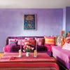Purple walls and a red sofa