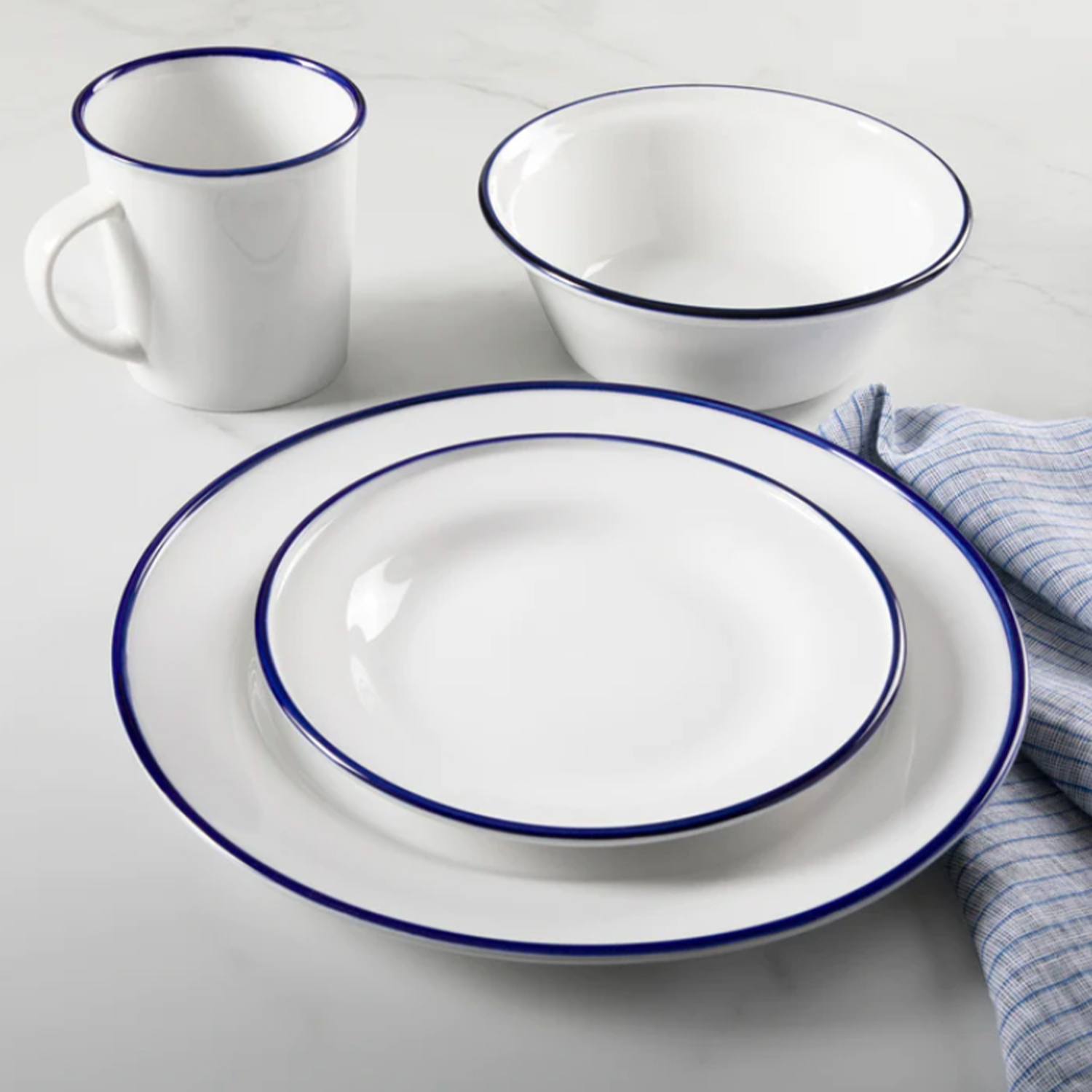 The Martha Stewart Cliffield 16-piece fine ceramic dish set with a navy blue rim