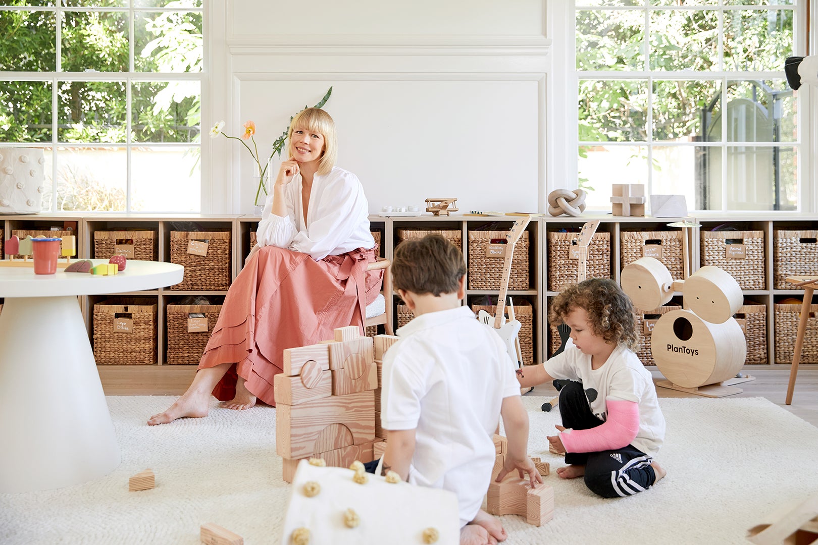 family in playroom with rows of bins behind them