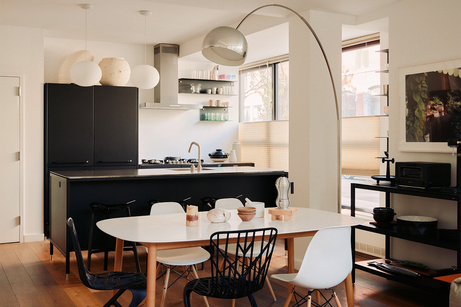 white dining table in front of black kitchen