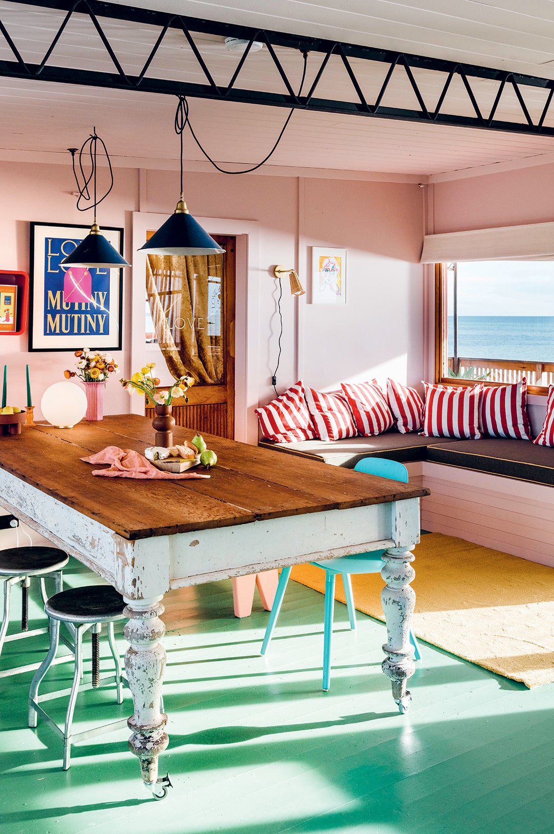 Dining room with pink walls and striped pillows