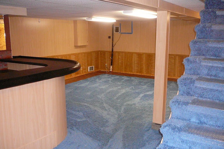 Before image of basement with blue shag carpet