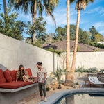 Couple standing by pool in their backyard