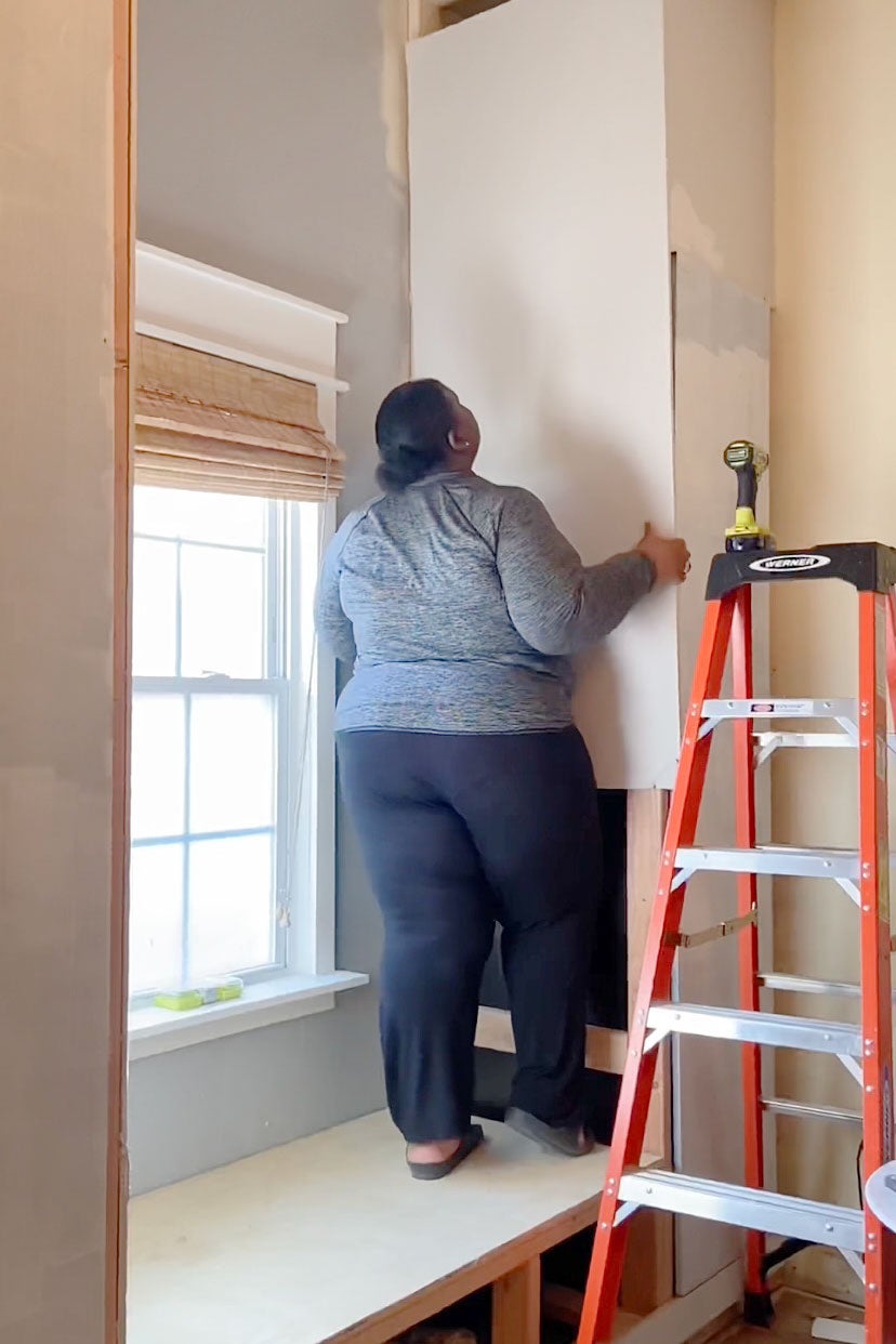 woman securing drywall