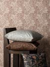 Marigold wallpaper in background with wood chair stacked with three pillows