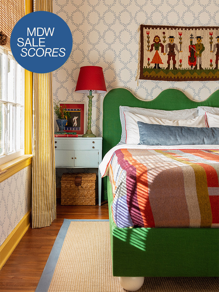 Colorful bedroom with green scalloped headboard and patterned quilt
