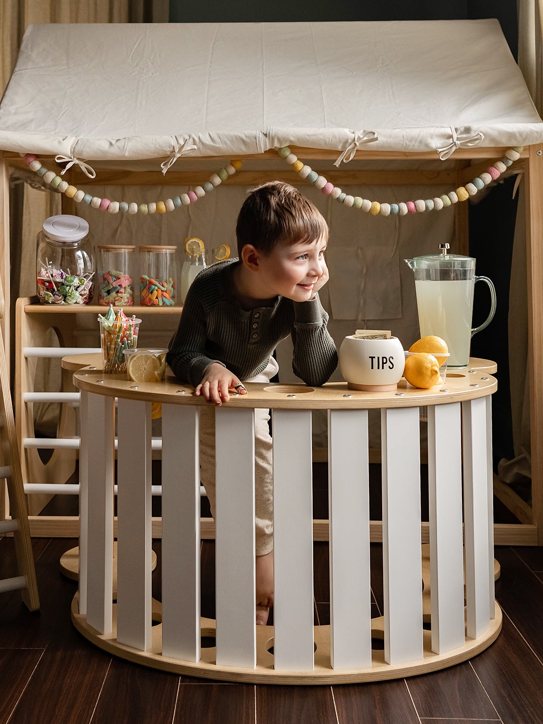 Little boy using the Cassarokids Jumbo Waldorf Rocker in Blanc as a lemonade stand