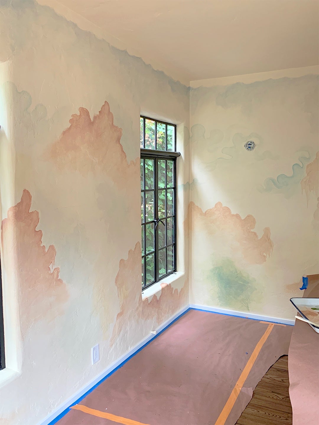 Room with pastel-like clouds on walls