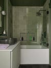 green bathroom with tub shower combo