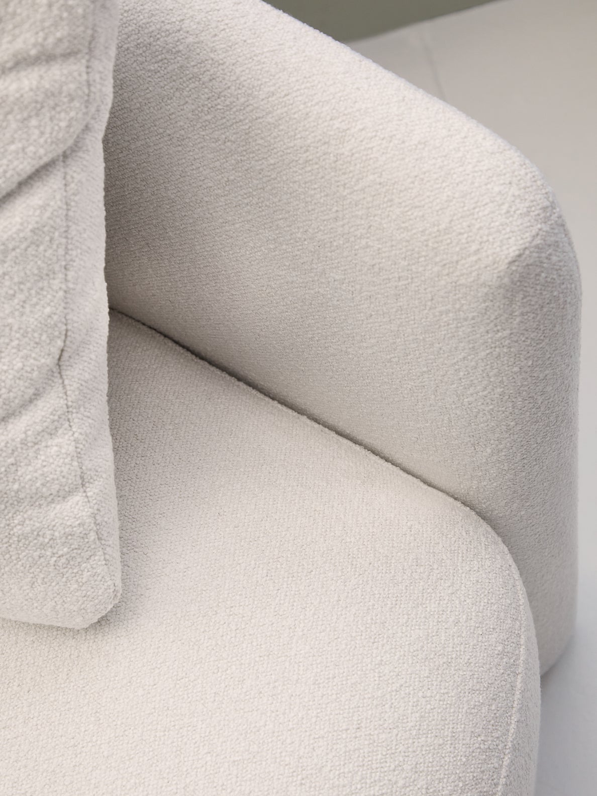 Close-up shot of The Drew Chair, a white boucle swivel chair