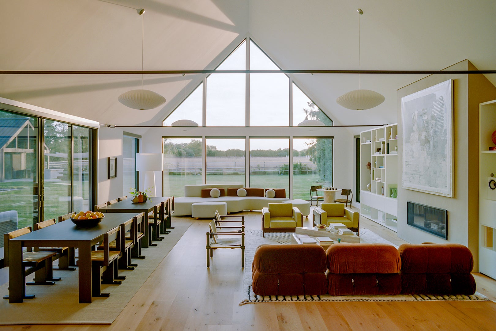 Light-filled living room with two sofas and two dining tables