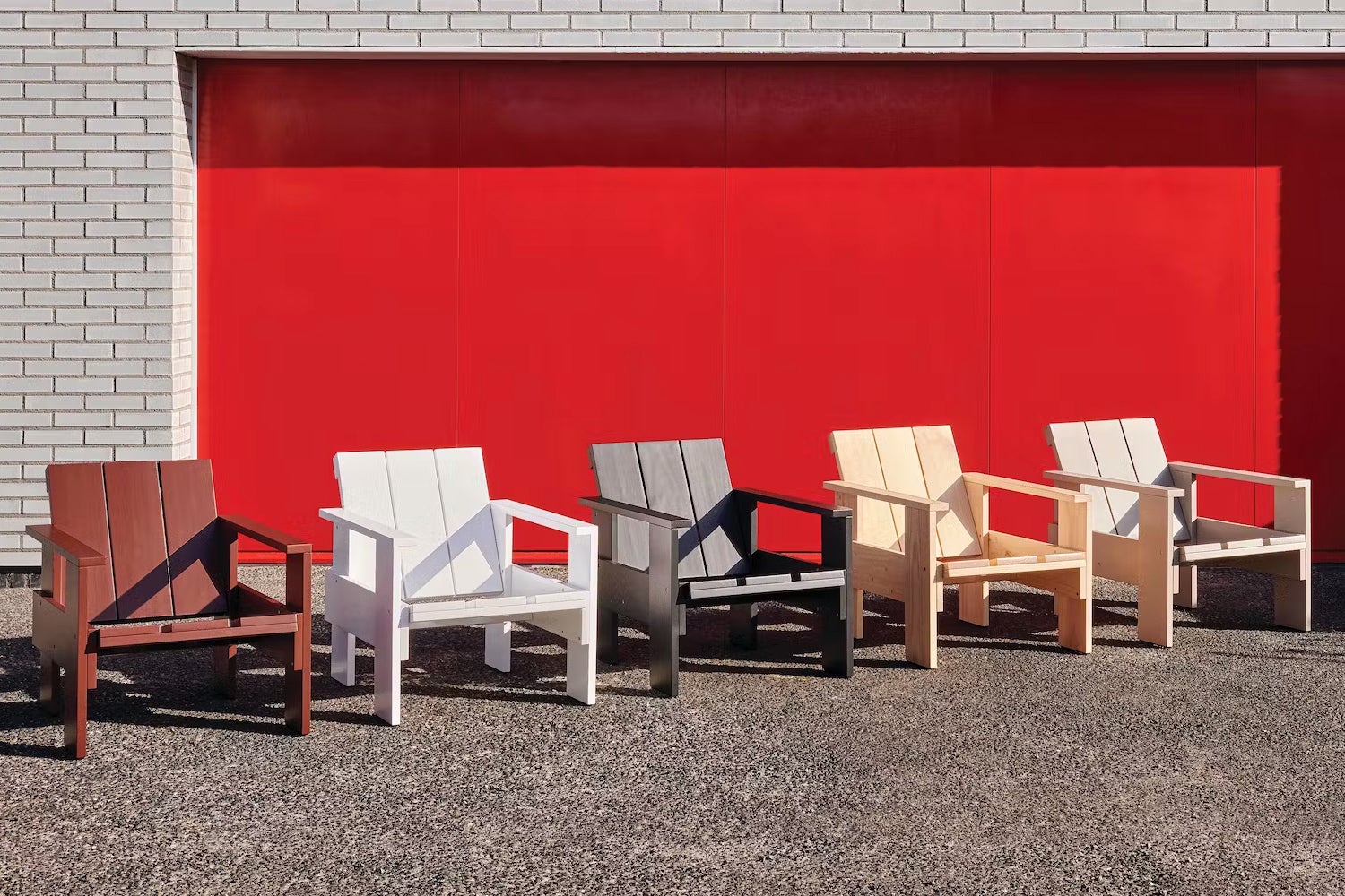 all crate chairs in different colorways outside of red and brick building