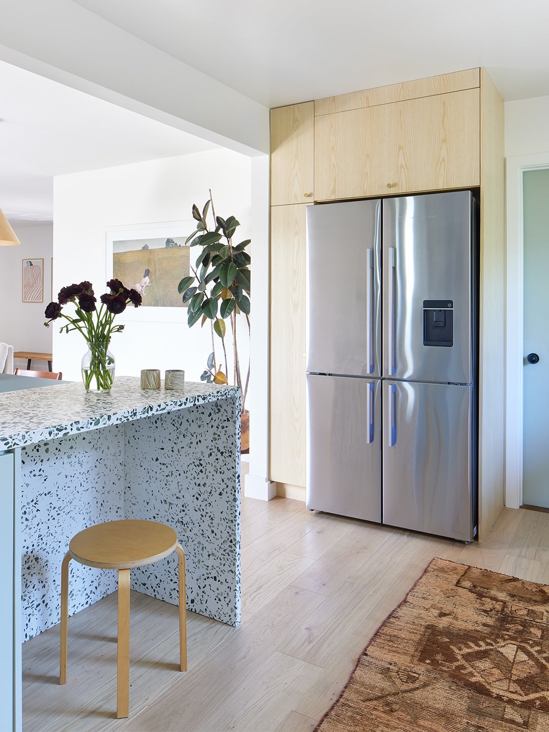 fridge surrounded by light wood cabinets