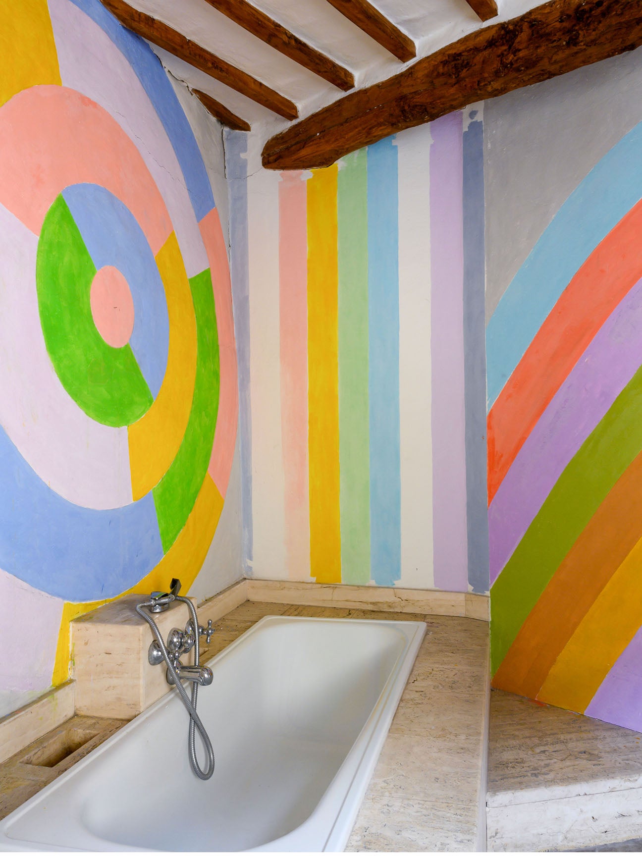 circular wall mural next to colorful stripes in bathroom